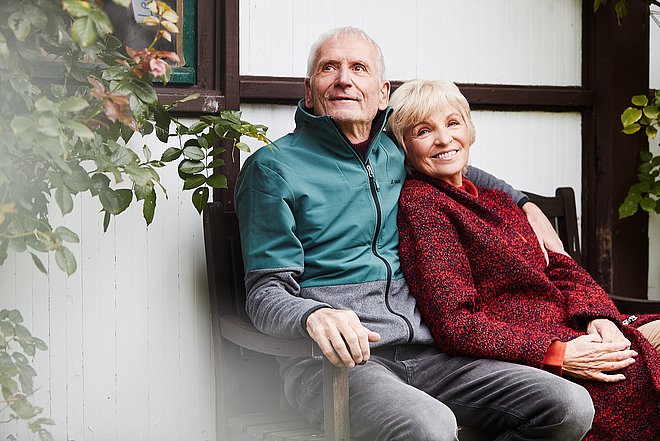 Ältere Personen sitzen auf einer Bank